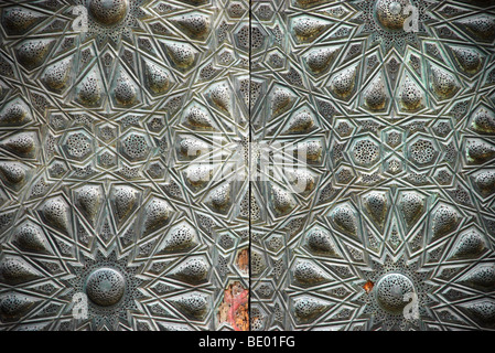 Bronzo metallico islamico Motivi geometrici su una porta di legno nella Moschea del Sultano al-Muayyad nel quartiere medievale del Cairo islamico, Egitto. Foto Stock