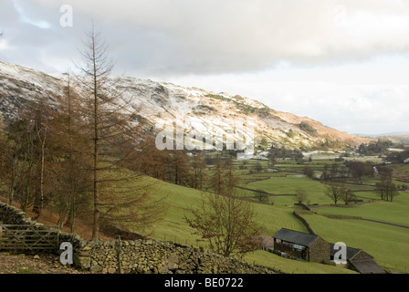 Guardando verso il basso sulla grande Langdale Valley al tramonto con il distante Snow capped Moutains, Lake District, Cumbria, Inghilterra Foto Stock