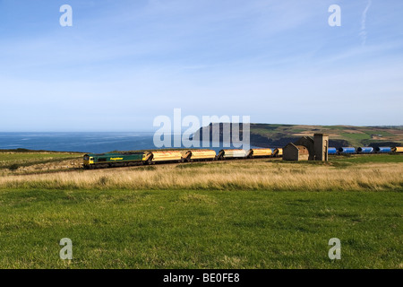 Un treno da Cleveland Potash miniera a Boulby passando il rovinato Guibal casa della ventola dall'ex Huntcliff miniera di ferro Foto Stock