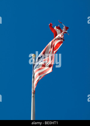 Strappato una bandiera americana sventola su un cielo blu. Foto Stock