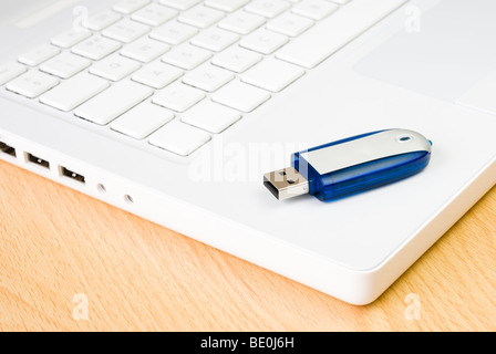 Laptop e flash USB pen drive disposti sul tavolo in legno Foto Stock