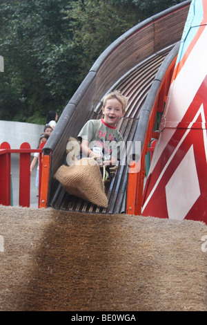 Ragazzo su Helter Skelter al luna park Foto Stock