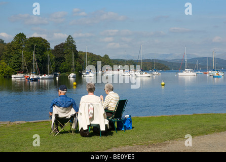 Tre persone rilassante cadde in piedi Park, Lago di Windermere, Parco Nazionale del Distretto dei Laghi, Cumbria, England Regno Unito Foto Stock