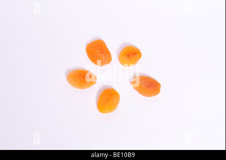 Una chiusura di alcune albicocche secche su sfondo bianco Foto Stock