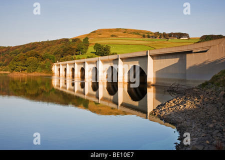 Il Viadotto Ashopton, riflessa nell'acqua ancora di Ladybower serbatoio, una delle dighe Derwent a Ashopton, Derbyshire Foto Stock