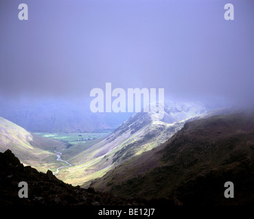 La luce del sole attraverso la rottura bassa nube su Mosedale e testa Wasdale dal vento alla distanza tra pilastro e Scoat cadde Lake District Cumbria Inghilterra England Foto Stock