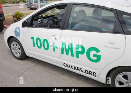Vista laterale di un ibrido plug-in la Toyota Prius auto con adesivi promozione 100+ miglia per gallone (mpg) e CalCars.Org. Foto Stock