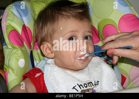 Ragazzo giovane essendo Spoon Fed Foto Stock