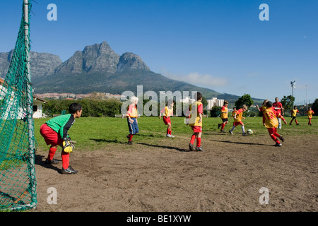 I bambini che giocano a calcio come una squadra, Cape Town, Sud Africa Foto Stock