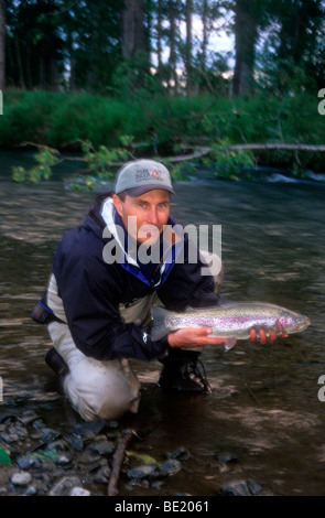 Pescatore con trote grosse arcobaleno, Kwethluk River, Alaska Foto Stock