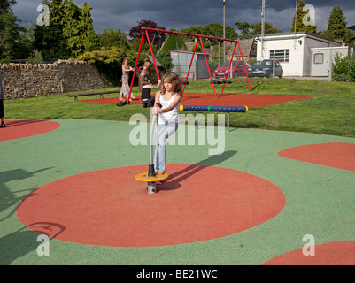 Ragazza che gioca la sicurezza attività di gomma materassino sul parco giochi a Broadway Activity Park WORCESTERSHIRE REGNO UNITO Foto Stock