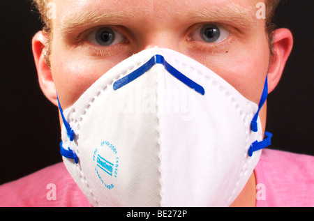 Giovane maschio di indossare la maschera protettiva nella lotta contro l'influenza suina Foto Stock