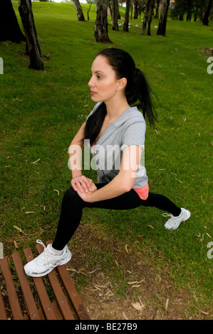 Royalty free stock foto della giovane donna di eseguire esercizi di stretching. Foto scattata a Pitman Park, Salisbury, Sud Australia Foto Stock