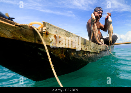 Pescatore con piroga, immersioni subacquee per il polpo, presi in Samoa, Foto Stock