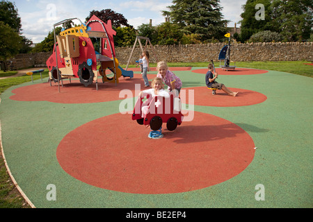 Ragazza che gioca la sicurezza attività di gomma materassino sul parco giochi a Broadway Activity Park WORCESTERSHIRE REGNO UNITO Foto Stock