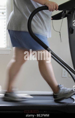 Donna sovrappeso esercitando su tapis roulant Foto Stock