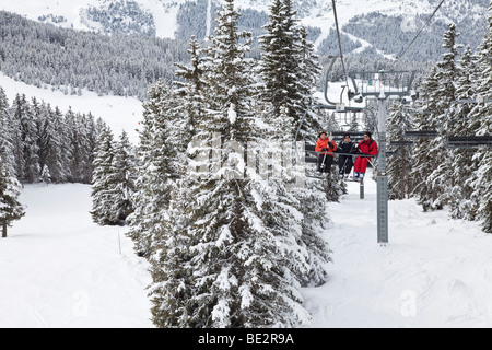 Gli sciatori in seggiovia, Méribel ski resort in tre valli, Les Trois Vallees, Savoie, sulle Alpi francesi, Francia Foto Stock