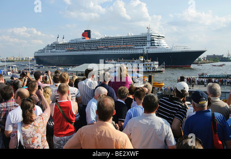 Gli spettatori a guardare la partenza della nave da crociera Queen Mary 2 dal Landungsbruecken, Ponti di Sbarco del porto di ha Foto Stock