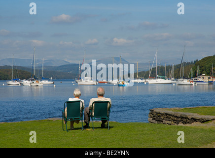 Coppia di anziani rilassante cadde in piedi Park, Lago di Windermere, Parco Nazionale del Distretto dei Laghi, Cumbria, England Regno Unito Foto Stock