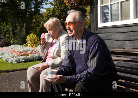 Regno Unito, Inghilterra, Staffordshire, Stafford, Victoria Park, bocce pavilion pensionati sat la visione di gioco nella luce del sole Foto Stock