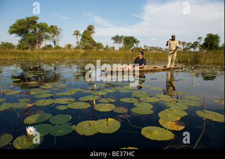 Turisti in viaggio mokoro, Okavango Delta, Botswana Foto Stock