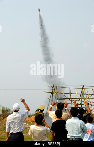 Rocket in aumento in cielo poco dopo il lancio di una piattaforma di lancio, allietarla spettatori, Pi Mai, Lao Anno Nuovo festival Foto Stock