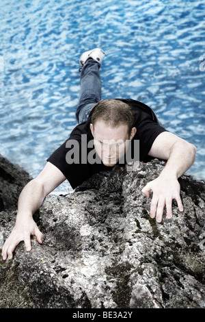Giovane uomo arrampicata Foto Stock