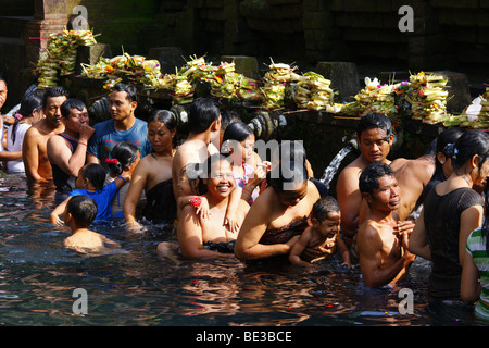 Persone in occasione di una cerimonia che si terrà presso la fonte sacra, Tirta Empul nei pressi di Tampak Siring nella luce del mattino, Bali, Repubblica di Indonesia, Sout Foto Stock