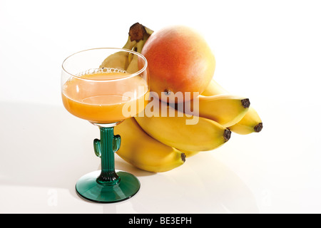 Mano di banane con un mango e succo di frutta Foto Stock