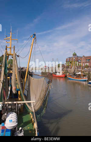 Fresa di gamberetti nel porto di Neuharlingersiel, taglierina con tirato-up attrezzi di pesca nella parte anteriore, il Wadden Sea National Park, Est Fr Foto Stock