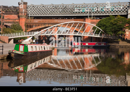 La Bridgewater Canal bacino narrowboats riflettente e mercanti e ponte nella zona di conservazione. Castlefield Urban Heritage Park, Manchester, Inghilterra, Regno Unito Foto Stock