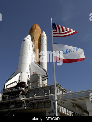 Alla NASA Kennedy Space Center in Florida, bandiere swing nel vento come lo Space Shuttle Endeavour si avvicina a Launch Pad 39A. Foto Stock