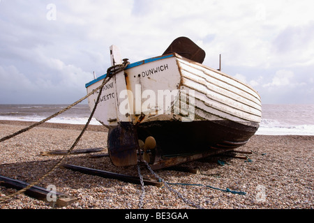 Un legno bianco pesca barca tirata su di una spiaggia di ciottoli Foto Stock