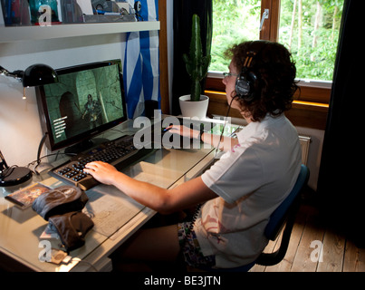 Un ragazzo, circa 15, la riproduzione di un gioco violento sul computer nella sua stanza, Germania, Europa Foto Stock