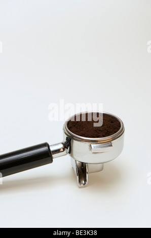 La preparazione professionale di espresso con una macchina espresso: riempimento del portafilter con caffè appena macinato Foto Stock