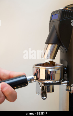 La preparazione professionale di espresso con una macchina espresso: Fase 1 - macinazione espresso nel filtro Foto Stock