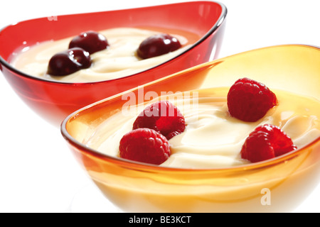 Budino alla vaniglia con ciliegie e lamponi in una ciotola di vetro Foto Stock