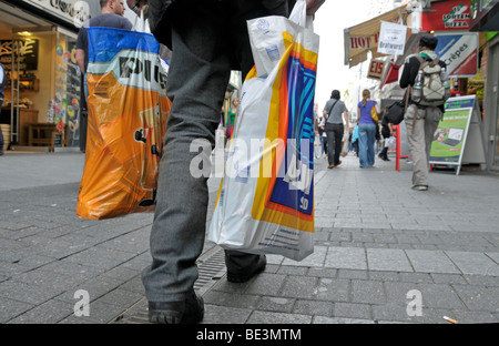 Il vecchio uomo dopo lo shopping al discount Aldi Sued e Plus, zona pedonale di Colonia, nella Renania settentrionale-Vestfalia, Germania, Euro Foto Stock