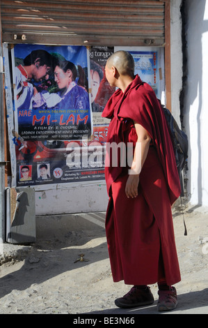 Monaco buddista guardando un moderno cinema pubblicità in Leh, Ladakh India del Nord, India, Himalaya Foto Stock