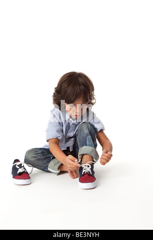 Little Boy legando la sua scarpa Foto Stock