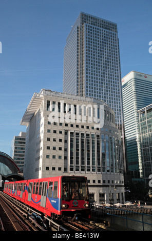 Un Docklands Light Railway in treno arrivando a Heron Quays con stazione di Canary Wharf in aumento in background. Foto Stock