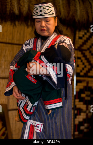 Un Ainu donna esegue una ninna nanna tradizionale canzone al poroto kotan Ainu museum di Shiraoi, Hokkaido, Giappone. Foto Stock