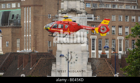 Il WEST MIDLANDS Air Ambulance elicotteri vola basso sul centro della città di Birmingham, UK Foto Stock