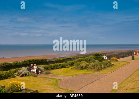 Due pensionati seduti su una panchina sul lungomare leggendo i quotidiani a Hunstanton , North Norfolk , Regno Unito Foto Stock