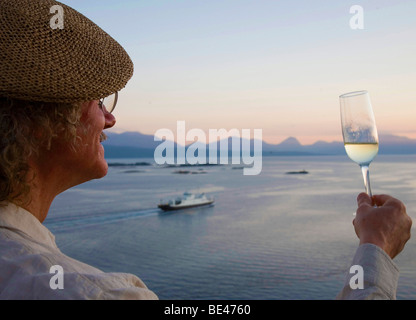 L'uomo con un bicchiere di champagne al fiordo di Molde, Norvegia, Scandinavia, Europa Foto Stock