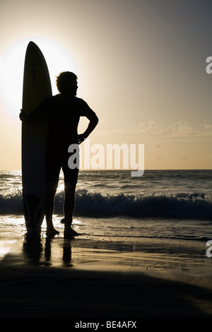 Un surfista si affaccia alle onde a Bondi Beach. Sydney, Nuovo Galles del Sud, Australia Foto Stock