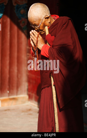 Il Tibetano monaca buddista pregando in Stupa Boudhanath a Kathmandu in Nepal Foto Stock