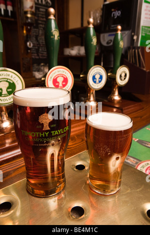 Regno Unito, Inghilterra, Yorkshire, Haworth, Vello Inn pinta e mezza di birra prodotta localmente Timothy Taylors birra su bar Foto Stock