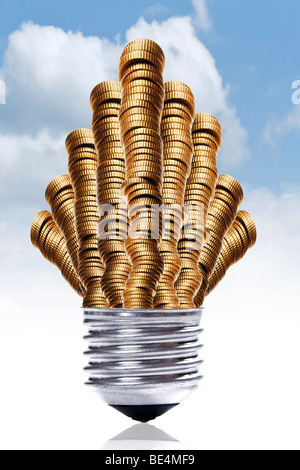 Pile di denaro nel montaggio di un bulbo di luce davanti a un cielo blu, simbolico per alti costi di elettricità Foto Stock