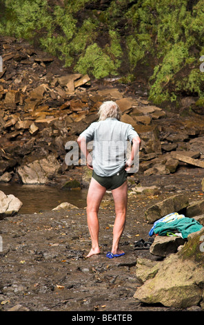 Uomo di vestirsi dopo una nuotata, forza Hardraw cascata, Wensleydale, Yorkshire Dales, England, Regno Unito Foto Stock